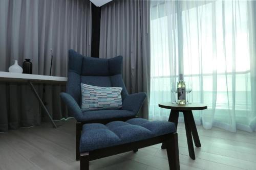 a blue chair sitting in a room with a table at Hotel Marea Vista in Ensenada