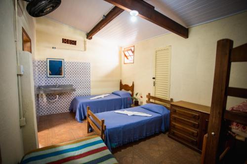a room with two beds and a sink in it at Hostel Casarão in Viçosa