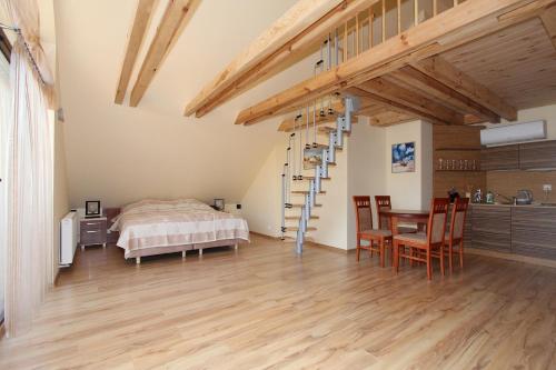 a bedroom with a bed and a table and chairs at Apartamenty & Restauracja NADMORSKA in Krynica Morska