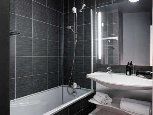 uma casa de banho com um lavatório, uma banheira e um WC. em Aparthotel Adagio Paris Montrouge em Montrouge