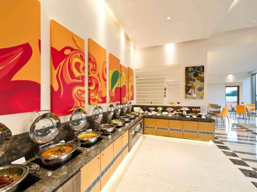 a kitchen with many bowls of food on a counter at ibis Nashik - An Accor Brand in Nashik