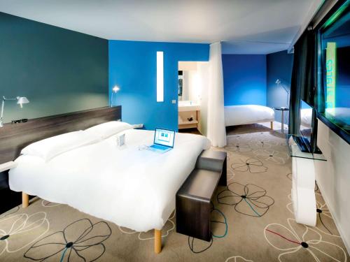 een slaapkamer met een wit bed en blauwe muren bij ibis Styles Brest Centre Port in Brest