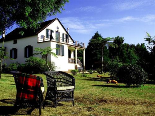 Vila Joaninha في سانتو دا سيرا: كرسيان أمام منزل أبيض