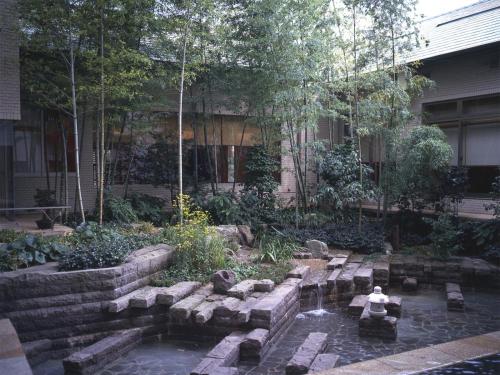 a garden with a pond in front of a building at Palace Hotel Kakegawa in Kakegawa