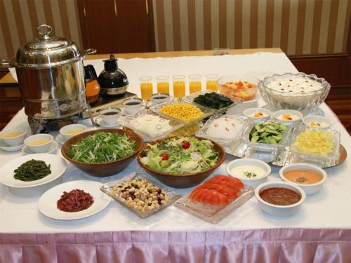 a table with many bowls of food on a table at Palace Hotel Kakegawa in Kakegawa