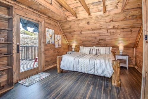 a bedroom with a bed in a log cabin at Bear Sightings! 8 mins to downtown Gatlinburg, Kids Cave, Theatre, Treehouse! in Gatlinburg