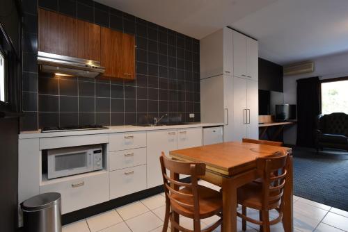 a kitchen with a wooden table and a microwave at Riverview on Mount Street in Perth