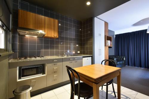 a kitchen with a table and chairs in a kitchen at Riverview on Mount Street in Perth