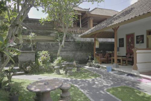 a garden in front of a house at Jero di Bisma Hostel in Ubud