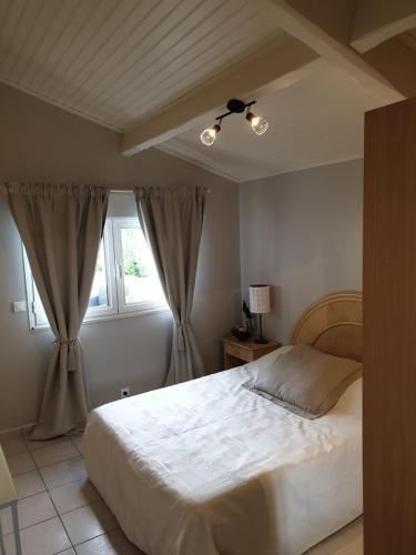 une chambre avec un lit blanc et une fenêtre dans l'établissement Plaisirs de Lège, à Lège-Cap-Ferret