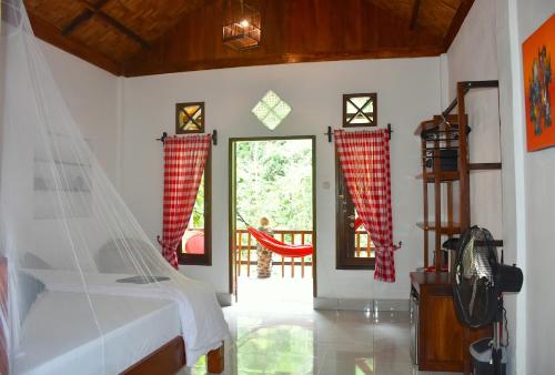 a bedroom with a bed and a sliding glass door at The Hangout@ EcoTravel in Bukit Lawang