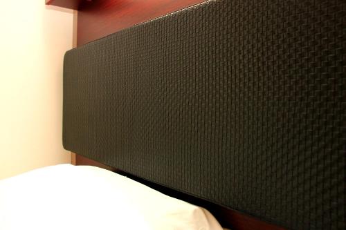 a black headboard of a bed in a room at Hotel Gobankan in Kumamoto