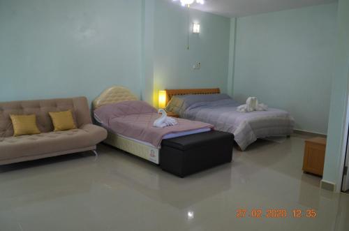 Briya Beachfront Residence في سيتشون: سريرين وأريكة في غرفة