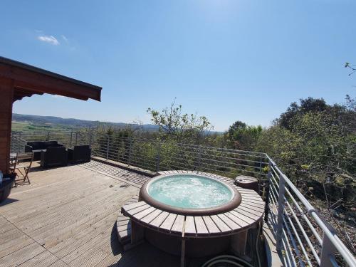 a wooden deck with a hot tub on top of it at Suite Nid d'Amour et Spa privatif in Vogüé