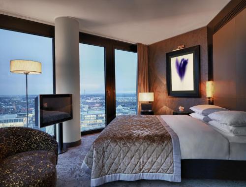 a bedroom with a large bed and large windows at Hyatt Regency Dusseldorf in Düsseldorf