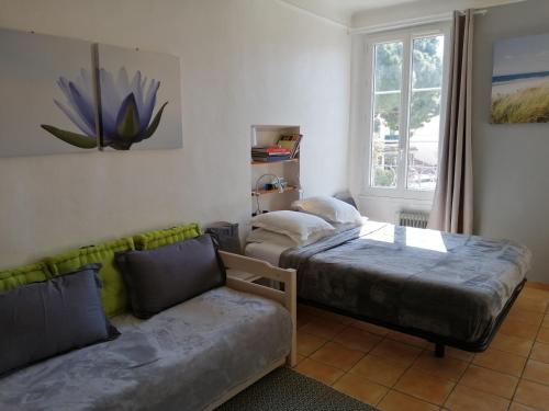 1 Schlafzimmer mit 2 Betten, einem Sofa und einem Fenster in der Unterkunft Saint Dizier in Cannes