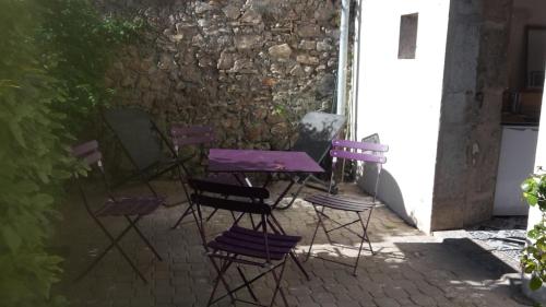une table et des chaises violettes assises dans une cour dans l'établissement Caraussane caractère terrasse sur jardin et wifi via fibre en coeur de ville, à Sète