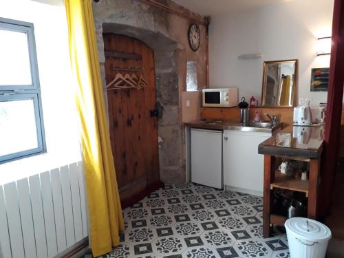 eine Küche mit einer Tür, einem Waschbecken und einer Theke in der Unterkunft Caraussane caractère terrasse sur jardin et wifi via fibre en coeur de ville in Sète