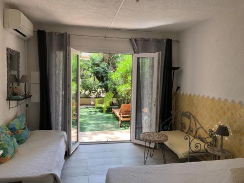 une chambre avec un lit et une porte coulissante en verre dans l'établissement Résidence les pieds dans l'eau, à Porto-Vecchio