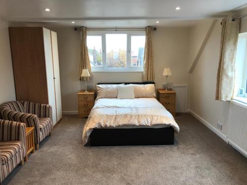 a bedroom with a bed and a chair and a window at 24 Elmhurst Road in Lytham St Annes