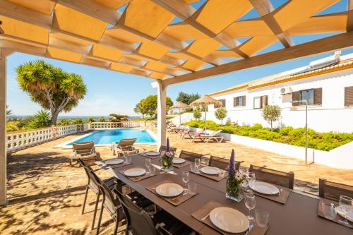 an outdoor dining area with a table and chairs and a swimming pool at Casa Katarina - Private Villa - Heated pool - Free Wifi - Air Con in Tunes