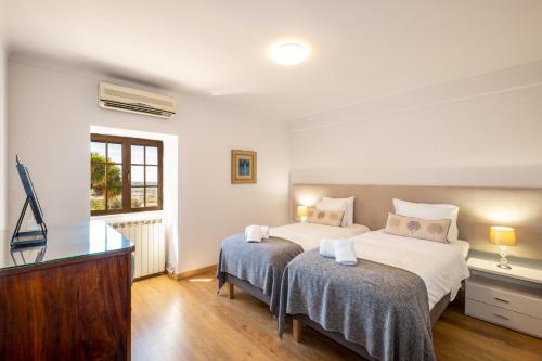 een slaapkamer met twee bedden en een televisie bij Casa Katarina - Private Villa - Heated pool - Free Wifi - Air Con in Tunes