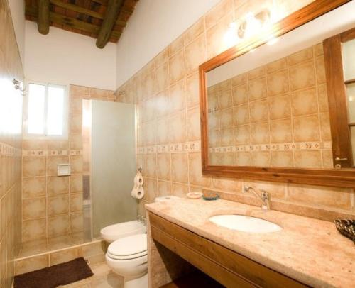 a bathroom with a sink and a toilet and a mirror at Golden Lodge in Paso de la Patria