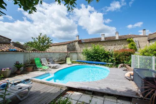 - une piscine dans un jardin avec une terrasse en bois dans l'établissement A L'Antan - La Ferme D'Octave, à Saint-Hilaire-de-Villefranche