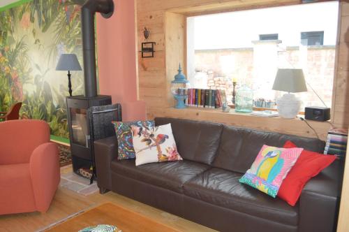 a living room with a brown leather couch with pillows at Das Nest in Eisenstadt