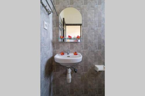 een badkamer met een wastafel en een spiegel bij Kubu Lestari Homestay in Sanur