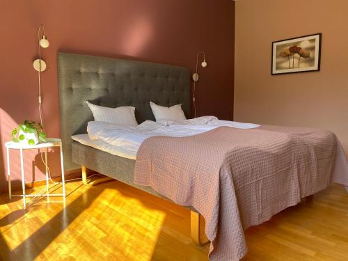 a bedroom with a large bed with a gray headboard at På Hörnet Hotell in Karlskrona