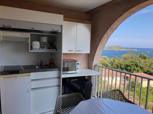 Il comprend une cuisine et un balcon offrant une vue sur l'océan. dans l'établissement Résidence les pieds dans l'eau, à Porto-Vecchio