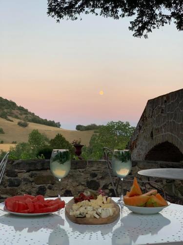 - une table avec deux verres de vin et de nourriture dans l'établissement Château de Perpezat, à Apchat