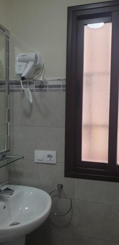 a bathroom with a sink, mirror, and shower stall at Pensión La Montoreña in Seville