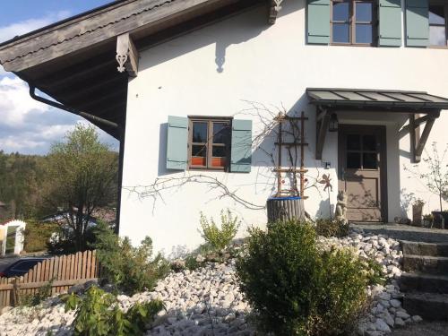 a white house with an orange door and windows at Entspannen mit Bergpanorama in Siegsdorf