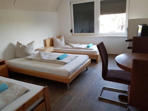ケチケメートにあるVándor Szállóのベッド2台、椅子、窓が備わる客室です。