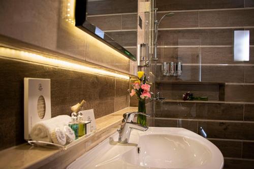 フリータウンにあるHome Suites Boutique Hotel Freetownのバスルーム(シンク、花瓶付)