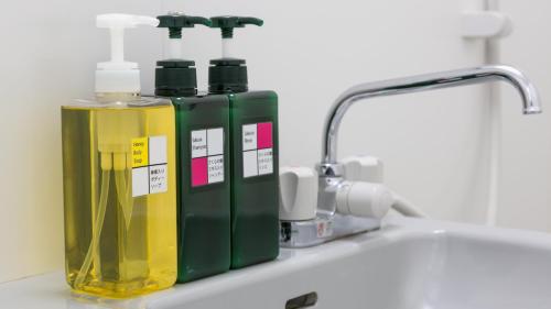 a sink with two bottles of soap and a faucet at Hotel Annex Inn in Shinhidaka