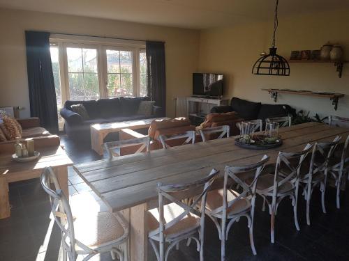 a living room with a large wooden table and chairs at B&B de Remketting in Slijk-Ewijk