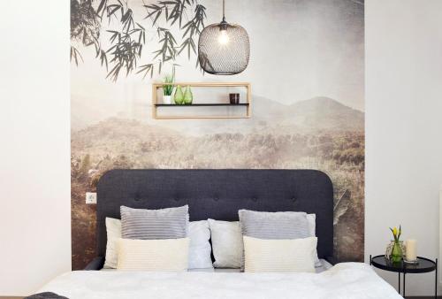 a bedroom with a large bed with white pillows at Design Apartment Stuttgart Messe-Airport Tiefgarage in Leinfelden-Echterdingen