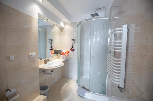uma casa de banho com um chuveiro e um lavatório. em Pensjonacik Grażyna em Ełk