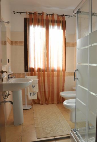 a bathroom with a sink and a toilet and a shower at B&B L'Ancora in Porto Torres