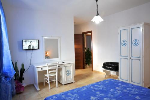 een slaapkamer met een bed, een bureau en een spiegel bij B&B L'Ancora in Porto Torres