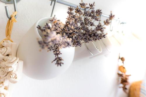 a white vase with flowers in it on a wall at Ferienwohnung am Ilztal in Hutthurm