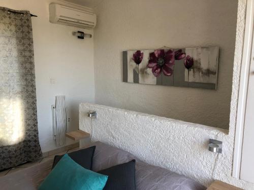 Cette chambre est dotée d'un mur avec une photo de fleurs. dans l'établissement Résidence les pieds dans l'eau, à Porto-Vecchio
