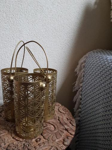 two gold baskets sitting on a table next to a bed at B&B de Remketting in Slijk-Ewijk