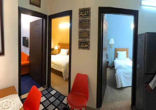 Habitación con dormitorio con cama y espejo. en Tourist Inn Apartment en Islamabad