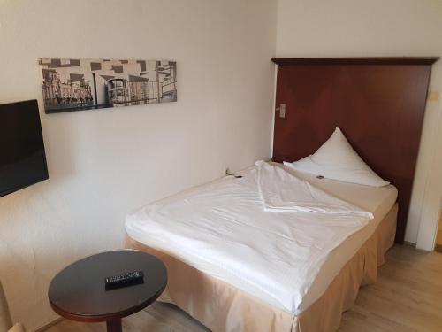 a small bedroom with a bed and a table at Hotel Pension Blüchersruh in Bad Berneck im Fichtelgebirge