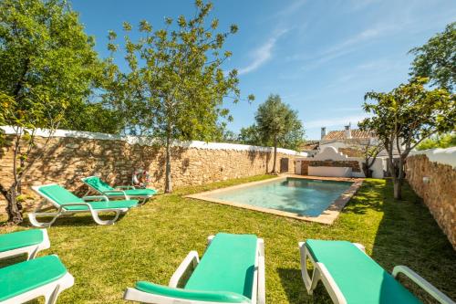 a backyard with lounge chairs and a swimming pool at Villa Monte Algarvio - Private Heated Pool - wifi in Tunes