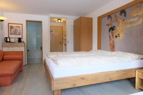 a bedroom with a large bed and a couch at Artist Apartments & Hotel Garni in Zermatt